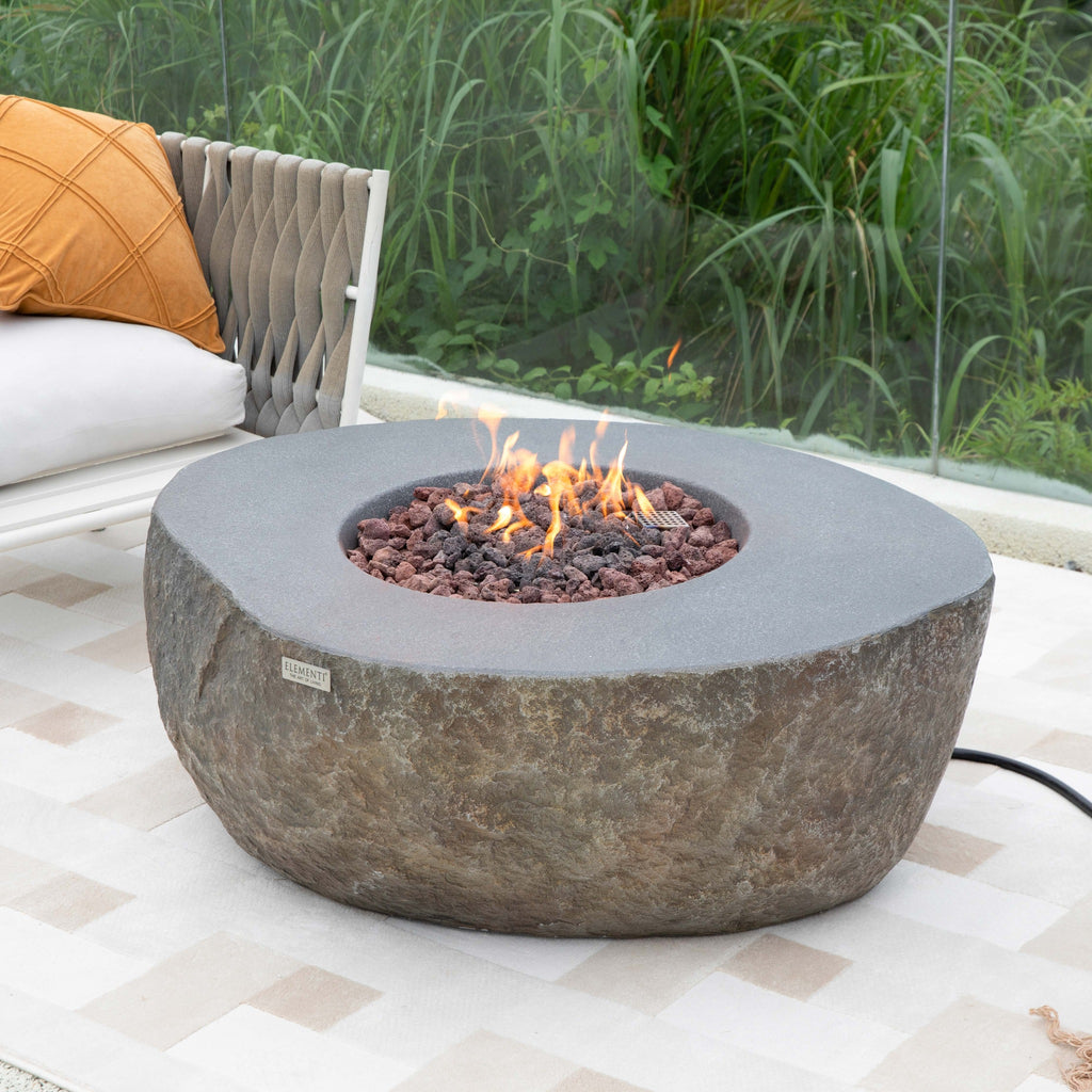 Elementi Boulder Fire Pit - Coastal Outdoor Terrace Setting with Modern Armchairs and Active Fire